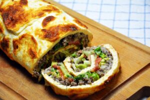 Big Mac roulade skåret i skiver med hakket oksekød, salat, tomat, bacon og dressing i midten