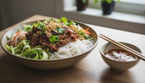 Asiatisk salat med risnudler, spidskål, syltede gulerødder og grillet grisekød