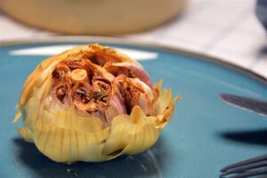 Hele bagte hvidløg i ovnfast fad med rosmarin og smør