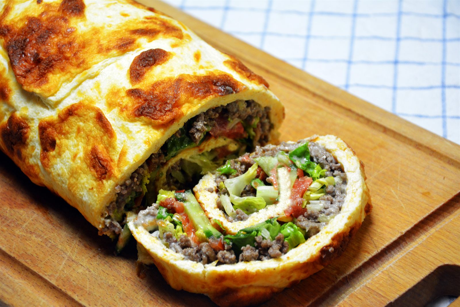Big Mac roulade skåret i skiver med hakket oksekød, salat, tomat, bacon og dressing i midten