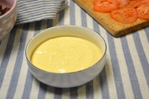 Hjemmelavet burgerdressing rørt cremet i en skål, klar til at blive smurt på burgerbollen