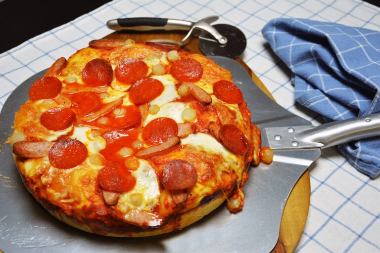 Deep pan pizza med tyk bund, smeltet mozzarella, pepperoni og syltede perleløg i en rund form