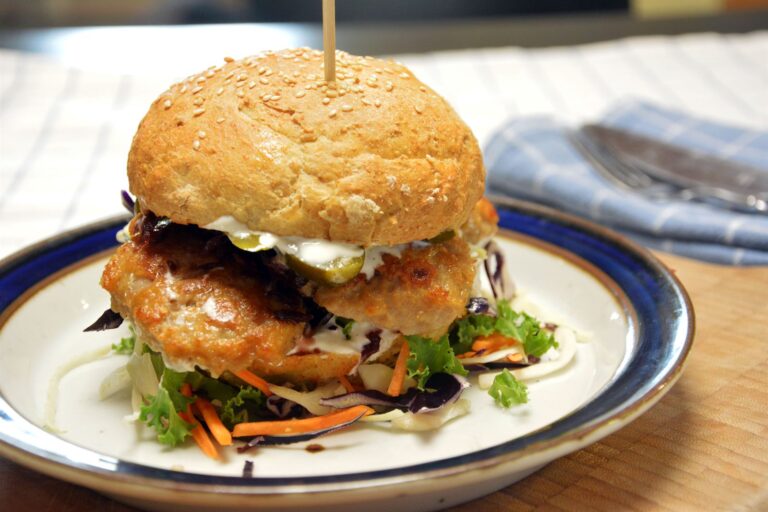 Frikadellesandwich i burgerbolle med snittet kål, syltet rødkål og syltede agurker, holdt sammen af et grillspyd af træ