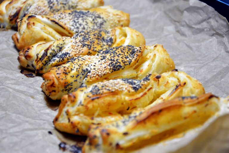 Nybagte frøsnappere af butterdej med blå birkes og sesamfrø på bagepapir