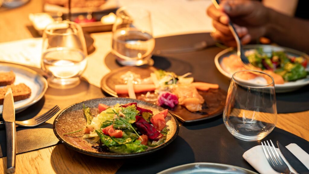 Aftensmad for to med salat og vin på et bord