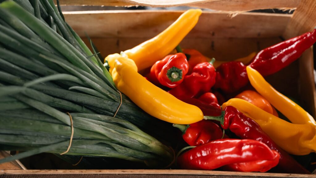 Kasse med peberfrugter, chili og porrer
